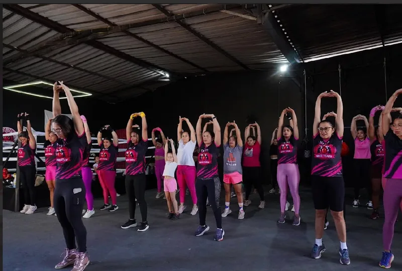 Turma feminina se alongando antes da aula